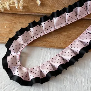 Detalle de cinta de encaje plisada de doble capa con lunares negros y rosas para manualidades