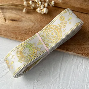 Detail of white elastic ribbon with gold magic circle patterns for DIY crafting and bows