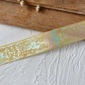 Detailed macro view of champagne gold ribbon with holographic laser snake and crown prints