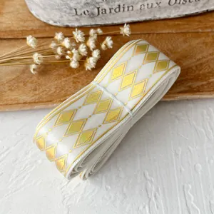 White decorative ribbon with golden geometric diamond pattern and shimmering glitter finish