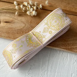 Detailed macro of pink satin ribbon with gold magic circle patterns for DIY handmade bows