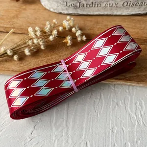 Macro shot of red ribbon with silver diamond patterns for DIY handmade gift wrapping