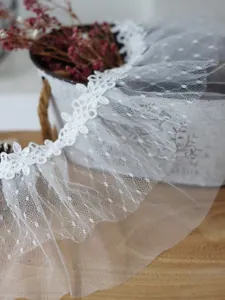 Nahaufnahme der 13 cm breiten weißen Blumenspitze mit gerafftem Punktmuster-Mesh