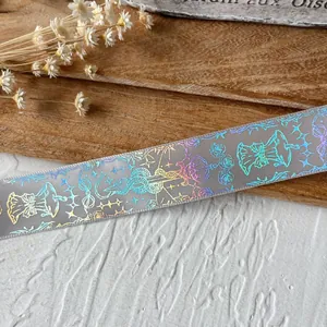 Holographic ribbon with stars and butterflies for DIY crafts on a wooden background