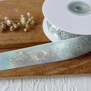 Silver decorative ribbon with laser holographic magic pattern on a white spool