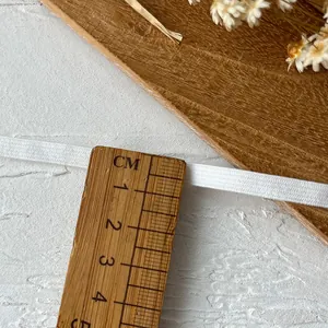 White 3mm thick elastic band measured with a ruler for sewing and DIY crafts