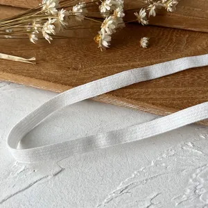 Thick white elastic band with woven texture on a wooden tray with dried flowers decor