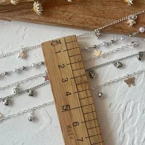 Macro view of silver alloy chains with star, heart, pearl and butterfly charms