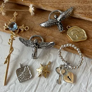 Détails d'un assortiment de breloques vintage avec anges, croix et pièces dorées