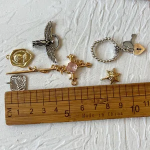 Vue détaillée de divers pendentifs en alliage d'or et d'argent avec règle de mesure