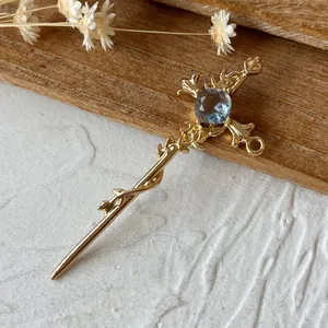 Détail macro du pendentif croix dorée avec gemme bleue et gravures de style gothique