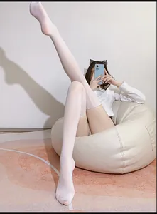 Close-up of white ultra-thin thigh high stockings with smooth glossy texture and reinforced cuffs