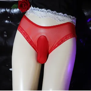 Detail of red sheer mesh men's erotic briefs with lace trim on a dark sofa