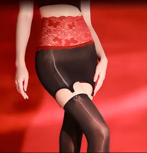 Close-up of red lace belt with black glossy stockings and suspender clips on lingerie