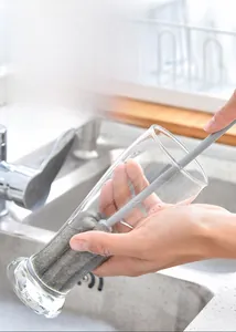 Long handle sponge cup brush cleaning a tall glass in a bright kitchen setting