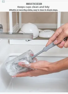 Deep cleaning action of a long-handle sponge brush inside a glass with rich soapy foam