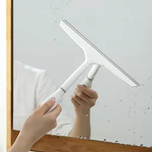 White ergonomic glass squeegee removing water droplets from a smooth mirror surface