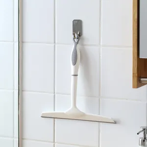 Minimalist white glass squeegee window cleaner hanging on a tiled wall hook