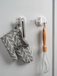 Detail of rotating wall hook with three branches showing kitchen utensils storage