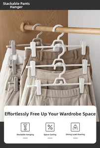 Detail of space-saving stackable pants hangers with adjustable clips in a wardrobe