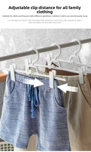 Detail of white plastic clothes hanger with adjustable clips for pants and skirts