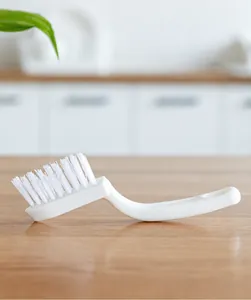 Close-up of V-shaped bristles on ergonomic grout brush for deep tile and corner cleaning