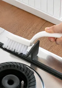 L-shaped crevice cleaning brush removing stubborn dirt from kitchen stove gaps