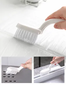 Detail showing stiff bristle crevice brush cleaning bathroom tiles and narrow gaps