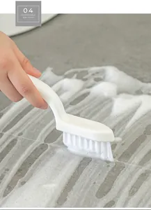 Macro detail of ergonomic gap cleaning brush scrubbing tile joints with active foam