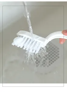 Detail showing high-foaming effect of white crevice cleaning brush under running water