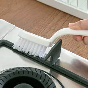 White ergonomic crevice cleaning brush for kitchen stoves and tile grout cleaning