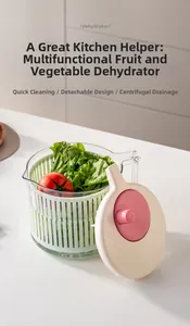 Close-up of a vegetable dehydrator set with a green basket and pink manual crank lid