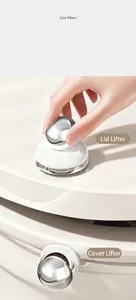 Detail of silver chrome toilet lid lifter handle with adhesive base on white ceramic surface