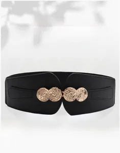 Detail view of women's wide elastic waist belt with vintage gold coin buckle and embossed design