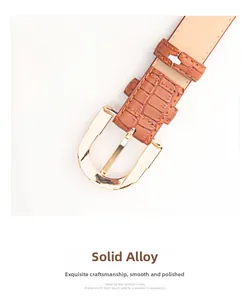 Detail of solid alloy golden D-buckle on a brown crocodile texture PU leather belt