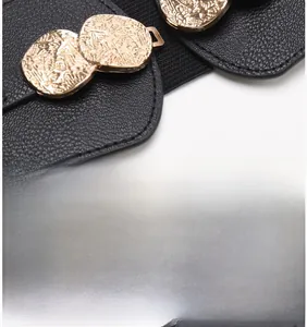 Detail of alloy interlocking buckle with hammered texture on black elastic waist belt