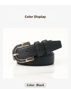 Detail of black faux leather belt with crocodile pattern and golden horseshoe buckle