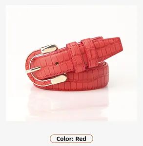 Close-up of red crocodile embossed PU leather belt with golden horseshoe buckle