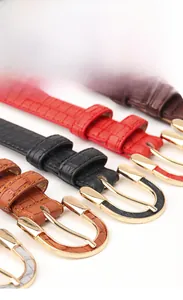 Detail of crocodile embossed PU leather belts with gold horseshoe buckles in four colors