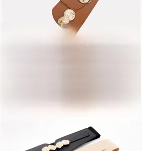 Detail of camel elastic waist belt featuring a hammered metal interlocking buckle