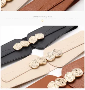 Detail of vintage coin buckle on elastic waist belt with pebbled leather and stretch fabric
