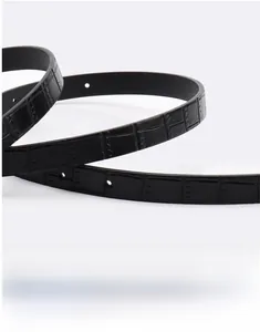 Detail of black faux leather belt showing crocodile texture and high-quality edge oiling