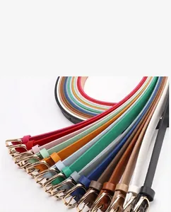 Détails de fines ceintures en cuir colorées avec boucles dorées ovales et coutures fines
