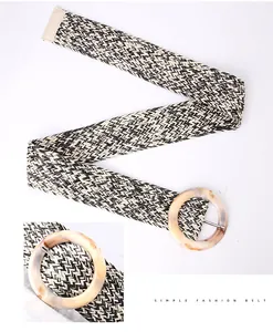 Dettaglio di cintura intrecciata con motivo a zigzag bianco e nero e fibbia in resina