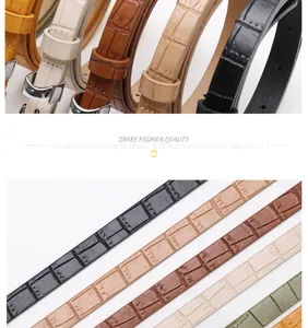 Detail of slim faux leather belts with stone texture and metal buckles in multiple colors