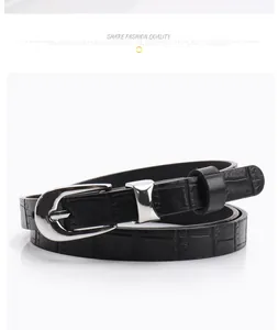 Close-up of black crocodile embossed faux leather belt with polished silver pin buckle