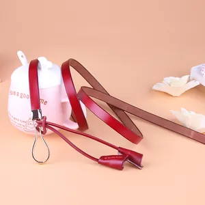 Ceinture fine en cuir bordeaux pour femme avec boucle fer à cheval dorée et glands