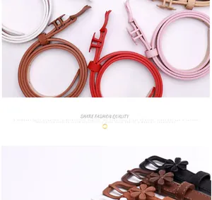 Close-up of thin leather belts with elegant flower buckles in various vibrant colors