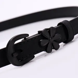 Women's slim black leather belt featuring a 3D floral buckle on a glossy white surface