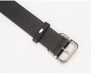 Detail of black lychee grain leather belt with square silver buckle and metal trim